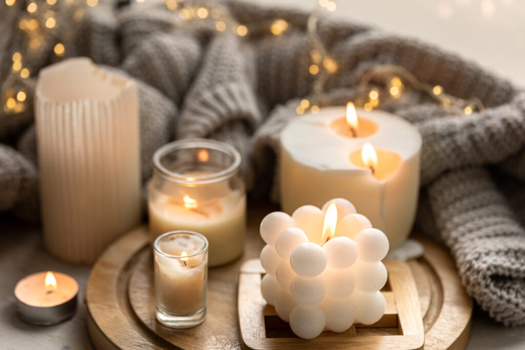 a cozy composition with candles, a knitted element and a garland.
